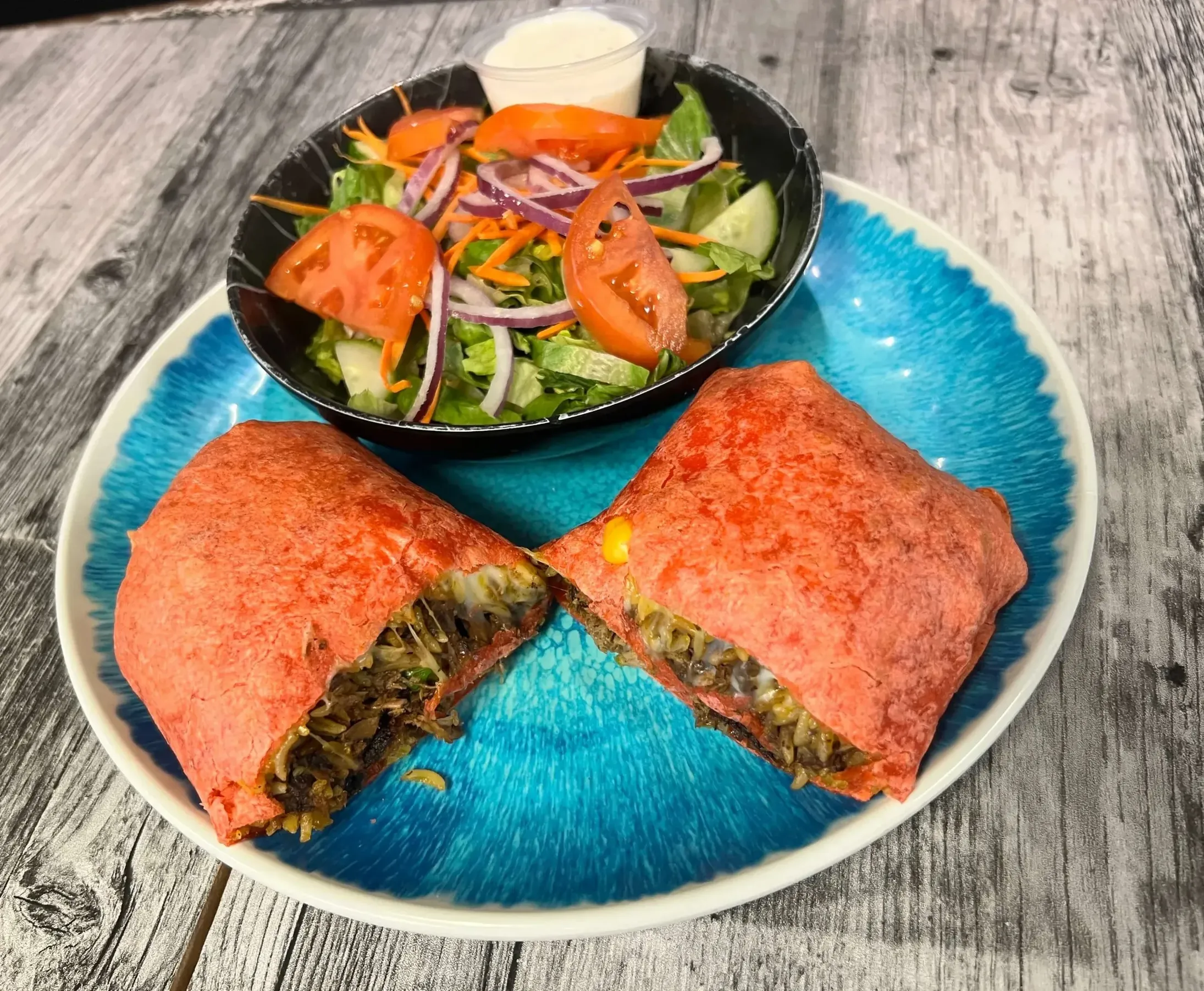 Gourmet wrap sandwich with a fresh side salad at Maison Croissant & Bowls near St Anne's Road, Winnipeg